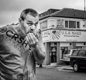 A man eating a donut in front of a building in Castleford.