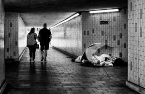 Two people walking through the Huddersfield tunnel with an umbrella.