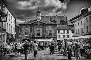 Street photography of people walking down a cobbled street.