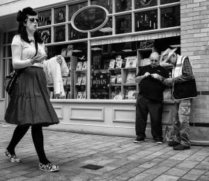 Street photography of a woman engrossed in her cell phone.