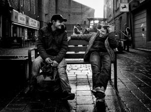 Street photography of two men on a bench.