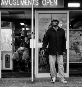 Street photography: A man standing in front of a store.