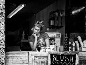 A woman enjoying a coffee while sitting at a coastal coffee shop.