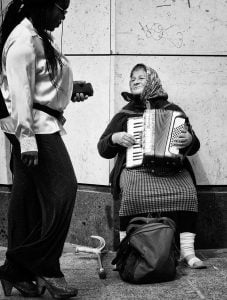 A woman playing an accordion by the coast.