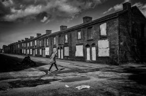 Street photography of a man walking down a black and white street.