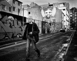 A man captured in street photography amidst graffiti.
