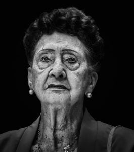 A black and white street photography of an old woman.