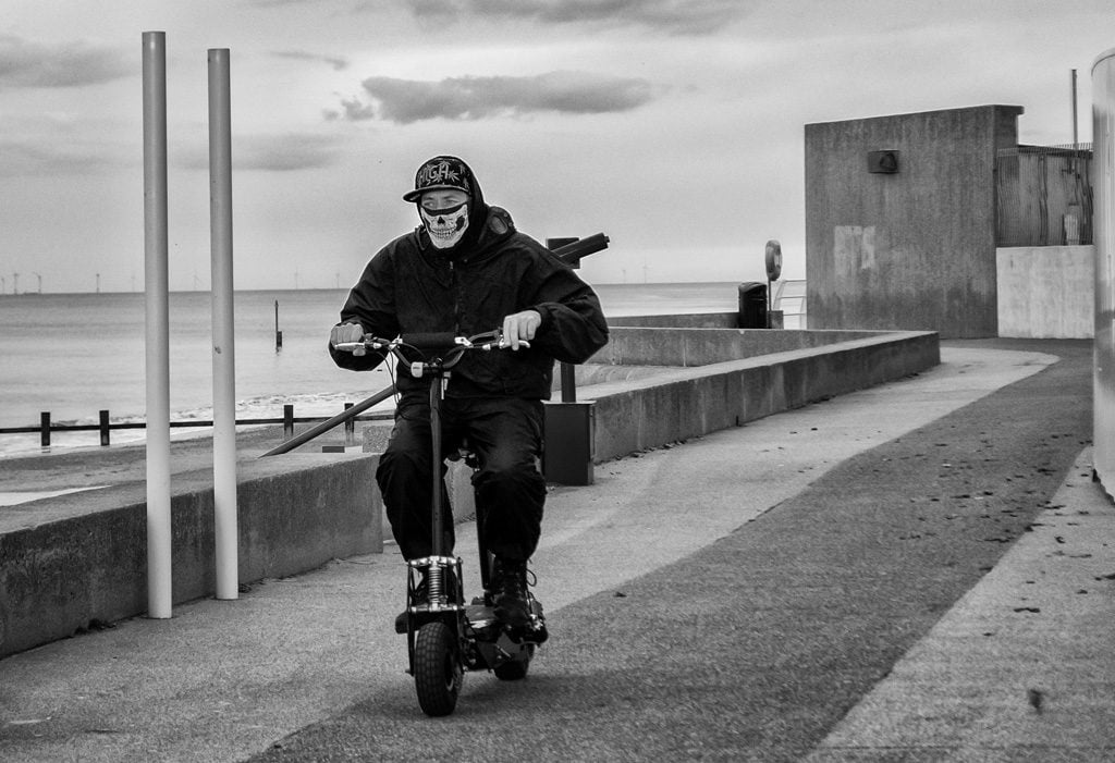 man in mask on scooter