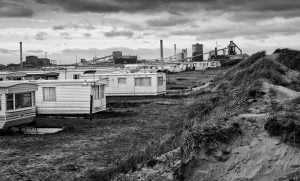 Black and white street photography of mobile homes in the sand.