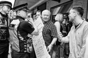 Street photography: Black and white photo capturing a police officer conversing with a man.