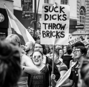 Woman holding a "Suck Dicks" banner at Leeds Pride 2019 photographs.