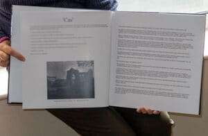 A person holding an open book displaying street photography.