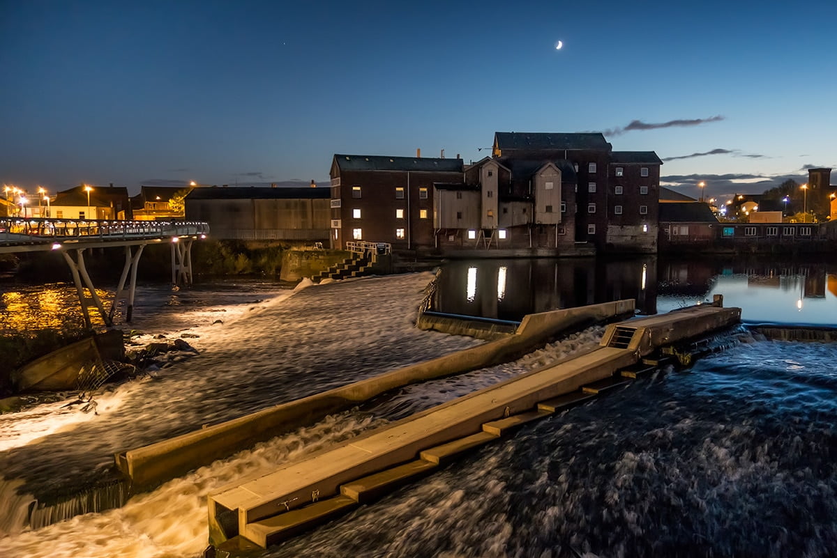 An exhibition showcasing a view of a river at night with a building in the background, Queen's Mill, October 2nd to October 18th 2021.