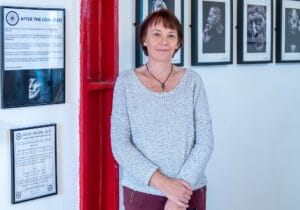 A woman exploring the Queen's Mill exhibition showcasing pictures on a wall from October 2nd to October 18th, 2021.