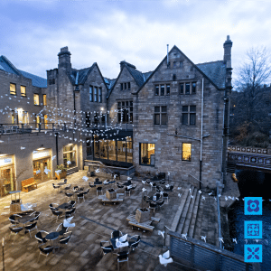 A courtyard with tables and chairs in front of a building, hosting the new After the Coal Dust Exhibition for 2022.